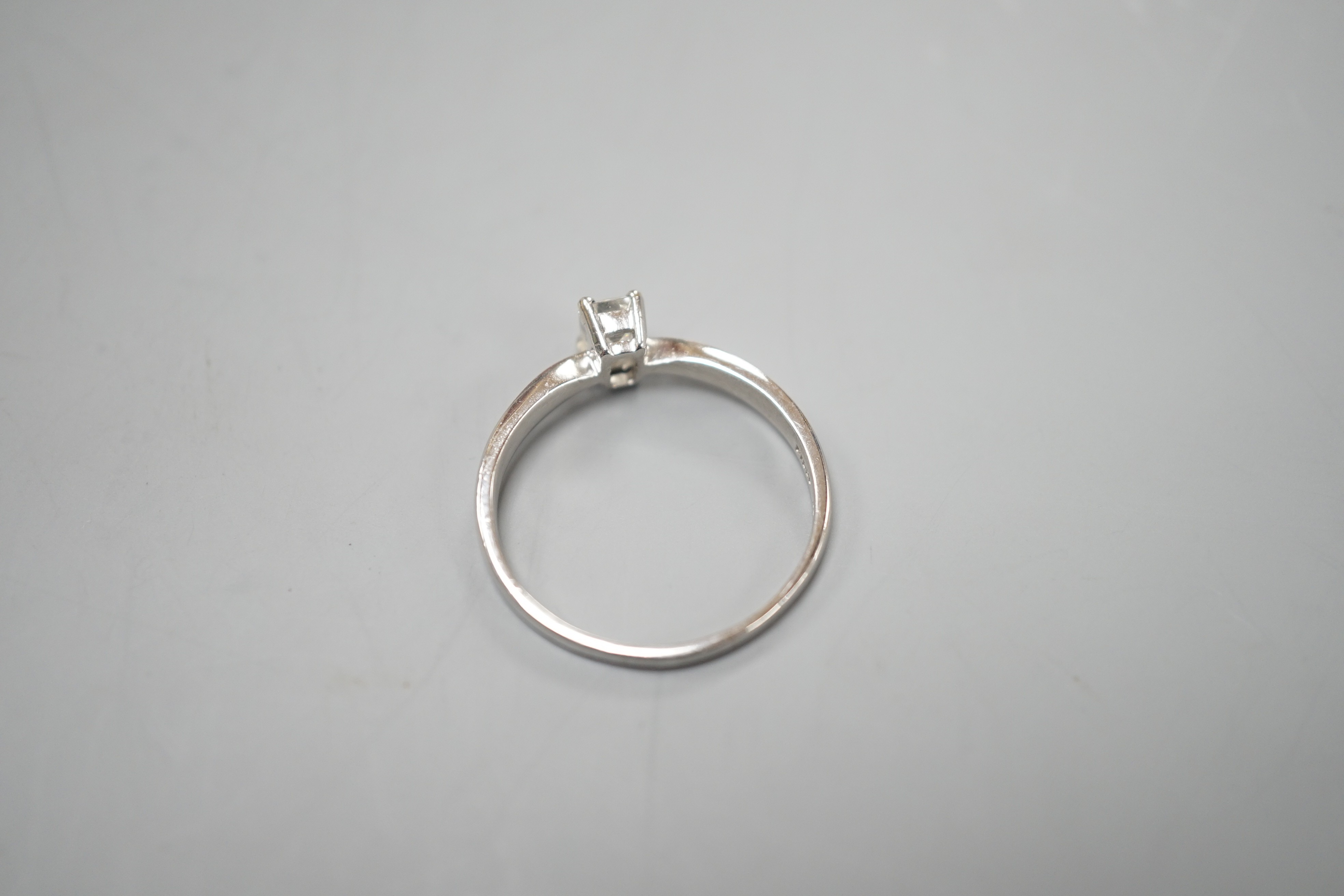 A modern platinum and solitaire emerald cut diamond set ring, size P/Q, gross weight 3.2 grams